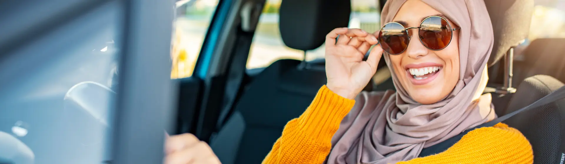 Portrait of Muslim woman driving a car in a happy mood.