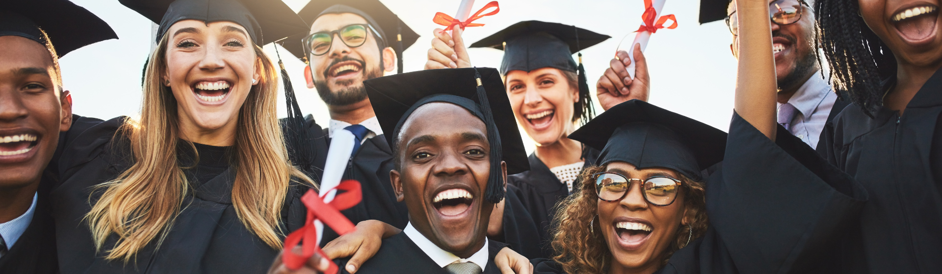 A group of diverse college students at their graduation ceremony celebrating the moment
