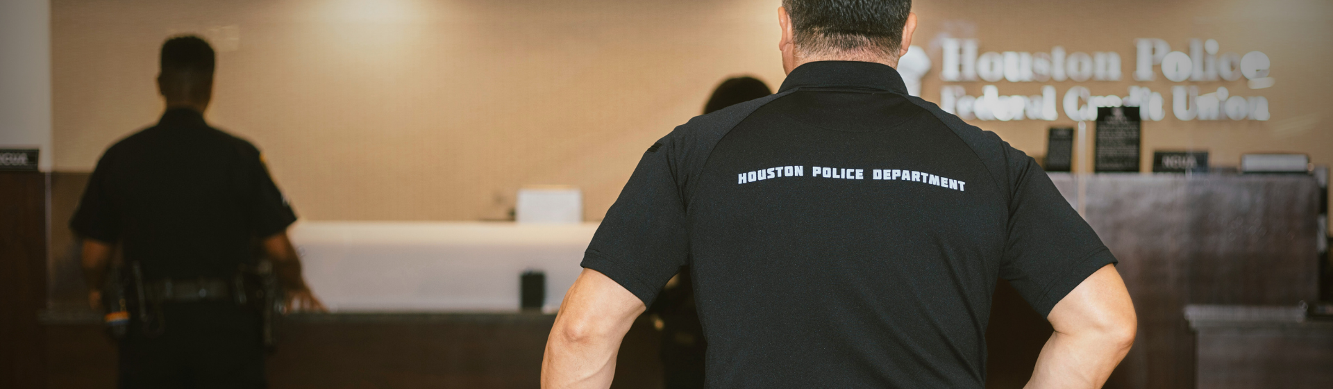African american male Houston Police officer greeting front desk african american female employee